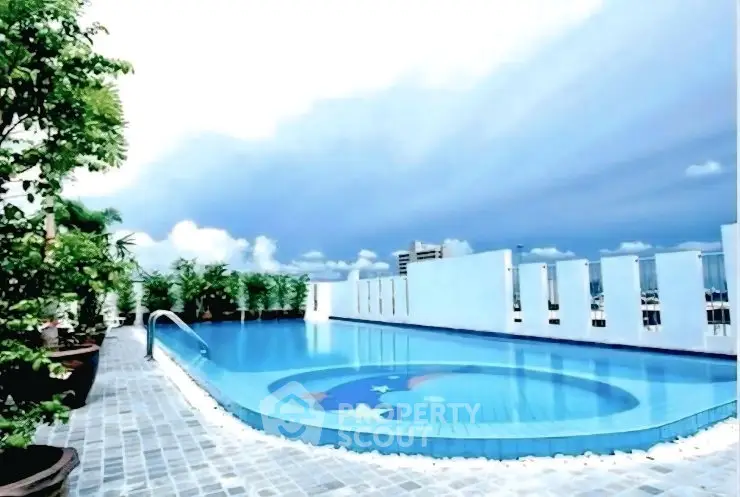 Stunning rooftop pool with panoramic city views and lush greenery.