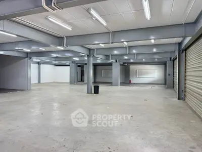 Spacious industrial warehouse with high ceilings and ample lighting, perfect for storage or business operations.
