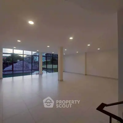 Spacious open-plan room with large windows and scenic view, ideal for versatile living space.