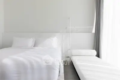 Modern minimalist bedroom with white bedding and natural light