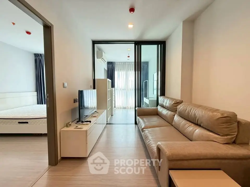 Modern apartment interior with spacious living room and bedroom, featuring sleek furniture and natural light.