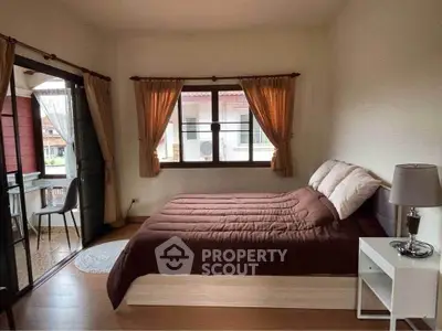 Cozy bedroom with balcony access and warm natural lighting.