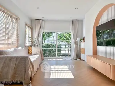 Bright and spacious living room with large windows and modern decor