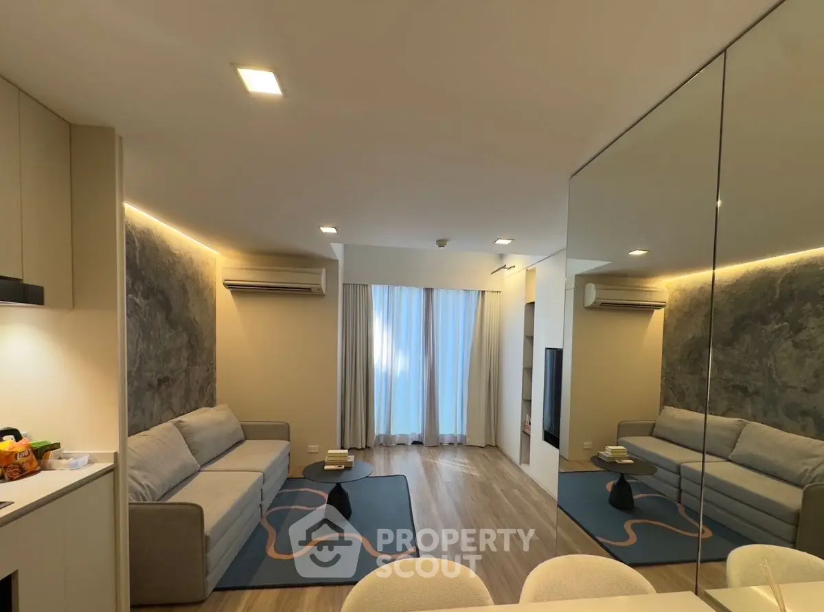 Modern living room with stylish decor and cozy seating area, featuring elegant lighting and a contemporary design.