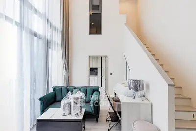 Luxurious modern living room with high ceilings and elegant staircase