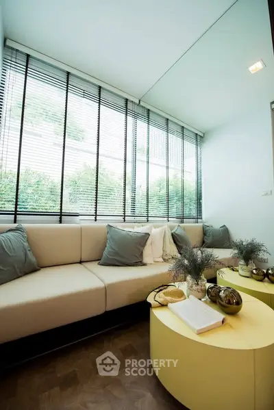 Modern living room with stylish decor and large windows offering natural light.