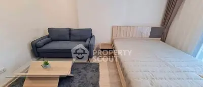 Modern studio apartment with cozy sofa and stylish bed setup.