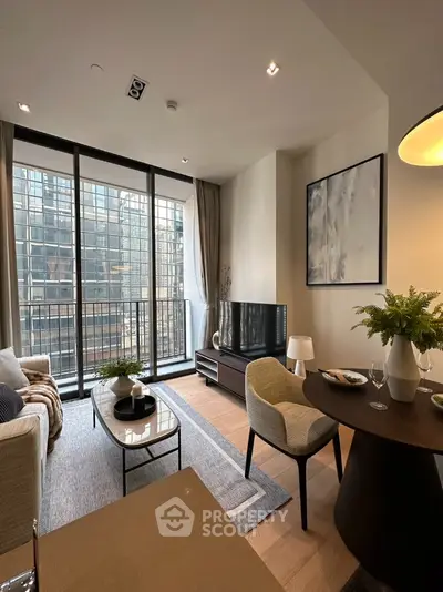 Elegant living room with modern furnishings, large windows, and balcony access, perfect for urban living and entertaining guests.