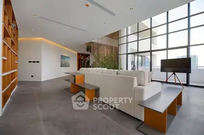 Spacious modern living room with floor-to-ceiling windows and sleek design.