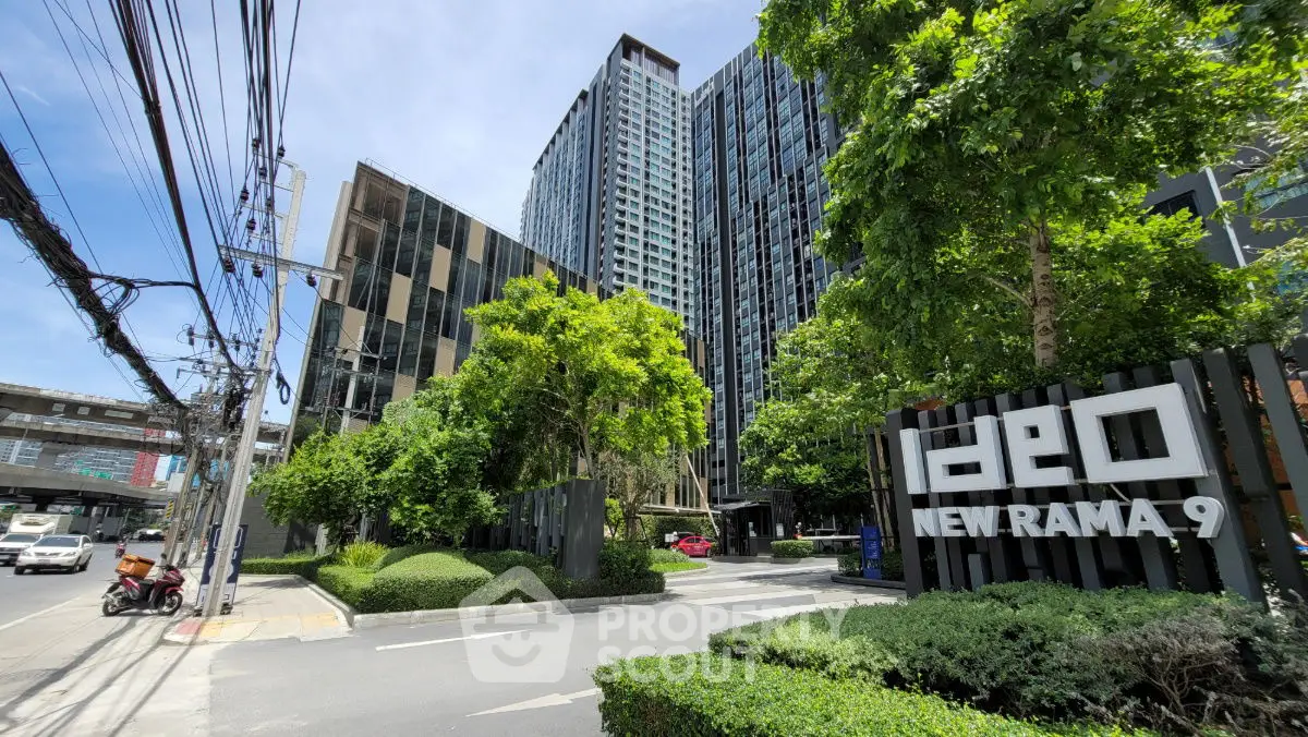 Modern high-rise building with lush greenery at Ideo New Rama 9, ideal urban living.
