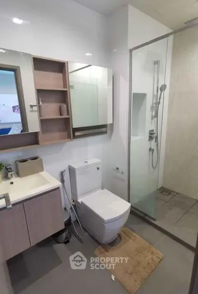 Modern bathroom with glass shower and sleek vanity in a contemporary home.