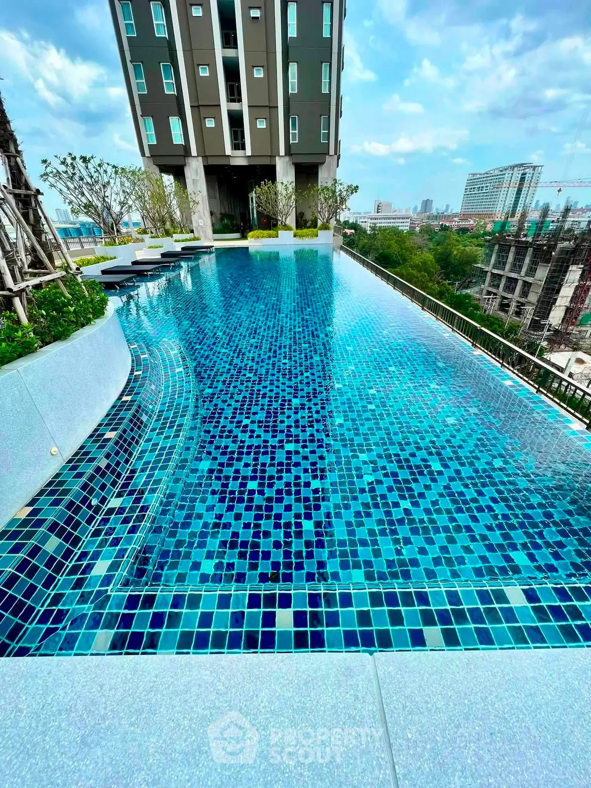 Luxurious rooftop pool with stunning city views in modern high-rise building.
