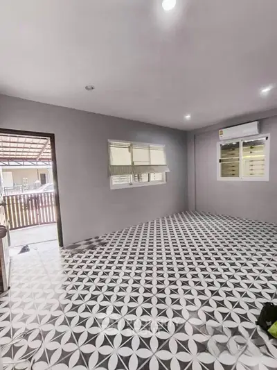 Spacious living room with patterned tile flooring and modern air conditioning.