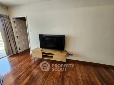 Spacious living room with sleek wooden floors and modern TV setup