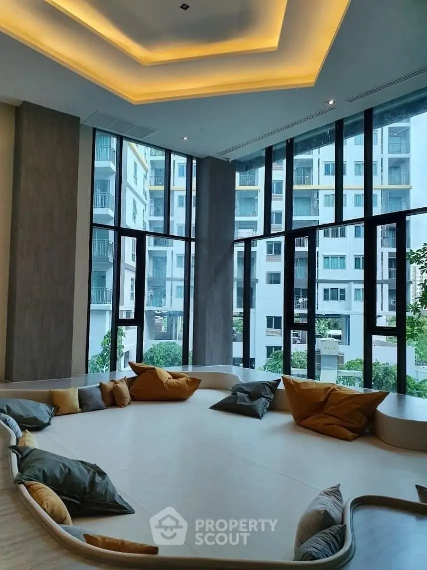 Luxurious modern living room with floor-to-ceiling windows and stylish seating area in a high-rise building.