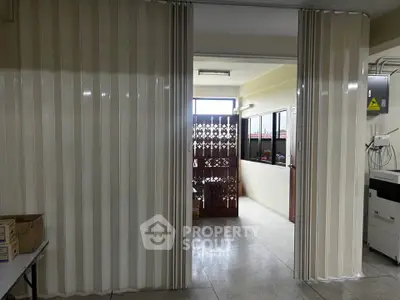 Spacious interior with sliding partition and natural light, ideal for flexible living or office space.