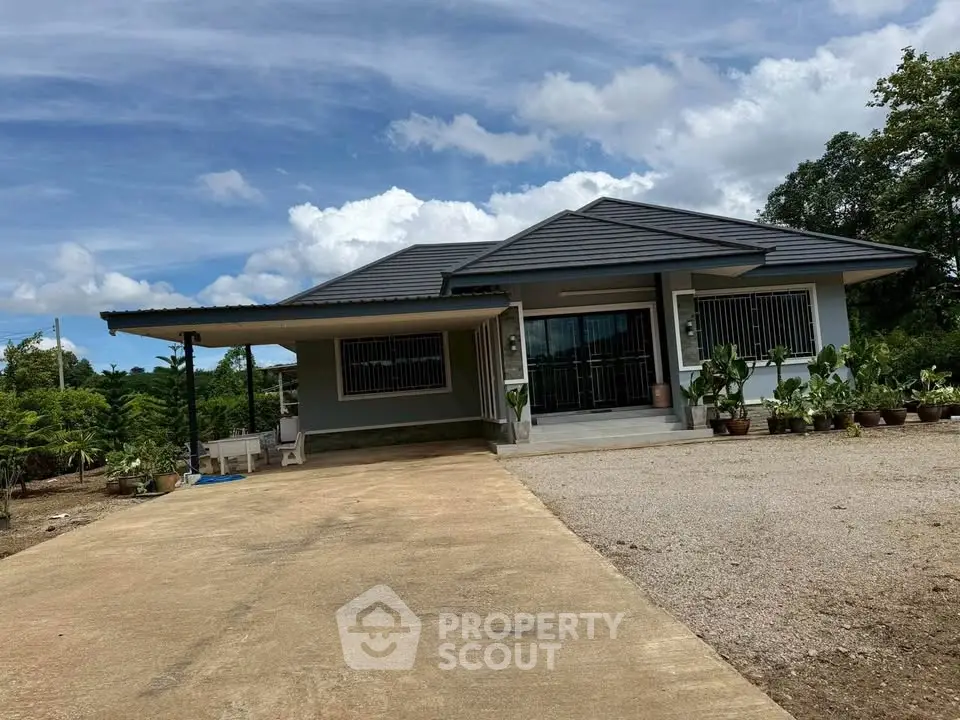 Charming single-story home with spacious driveway and lush greenery, perfect for serene living.