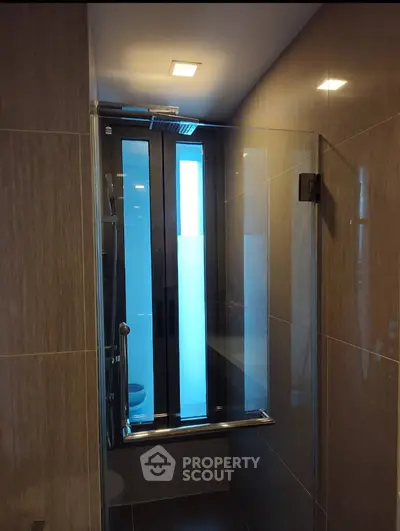 Modern bathroom with sleek glass shower and elegant tile design.