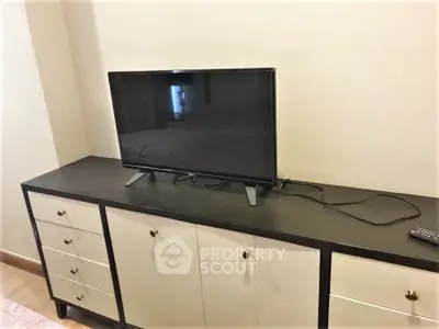 Modern bedroom with sleek TV on stylish cabinet, perfect for relaxation and entertainment.