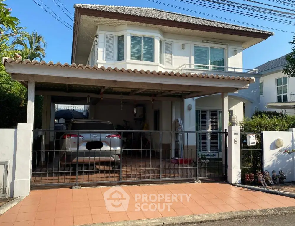 Charming two-story house with carport and gated entrance in a serene neighborhood.