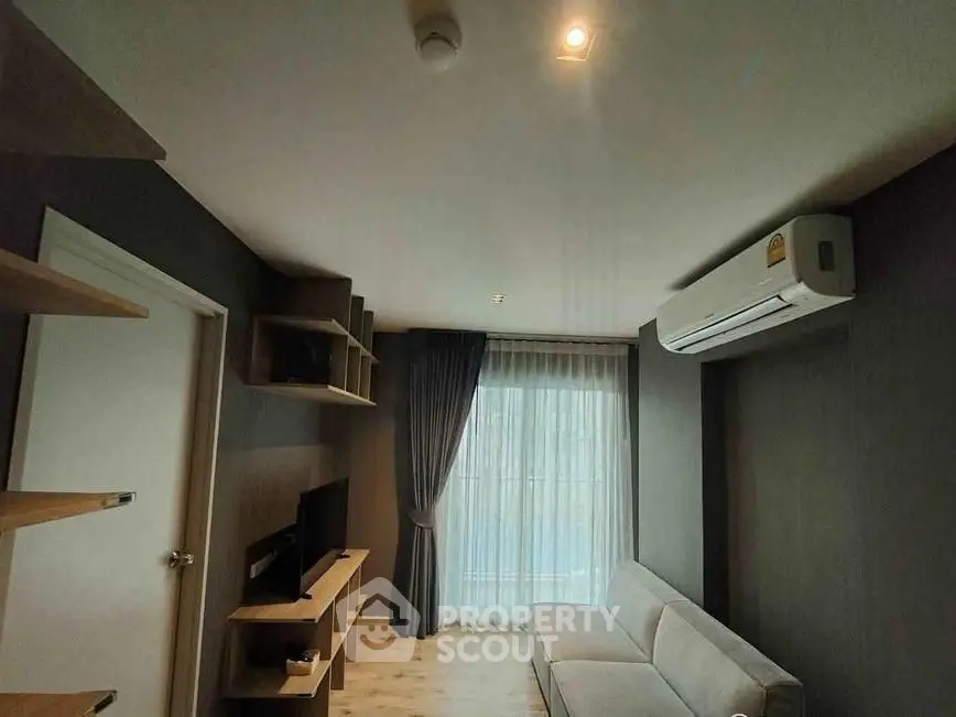 Modern living room with sleek design, featuring a cozy sofa, wall-mounted TV, and large window with curtains.