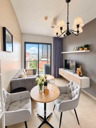 Chic modern living room with elegant chandelier and cozy seating area, perfect for relaxation and entertainment.