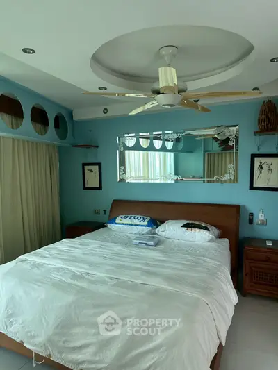 Spacious bedroom with modern ceiling fan and elegant decor