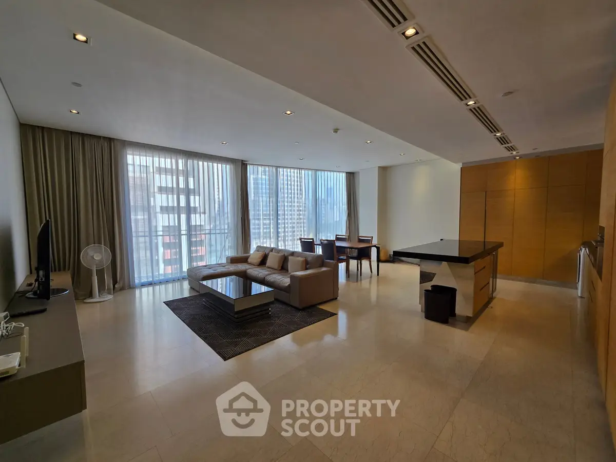 Spacious modern living room with city view, featuring elegant furniture and natural light.