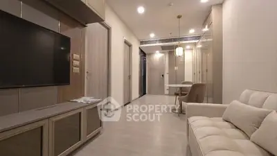 Modern living room with sleek design and neutral tones, featuring a comfortable sofa and wall-mounted TV.
