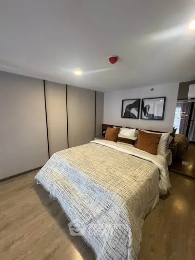 Modern bedroom with stylish decor and cozy ambiance, featuring a comfortable bed and elegant artwork.