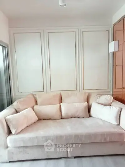 Elegant living room with plush beige sofa and modern paneling, perfect for relaxation and style.