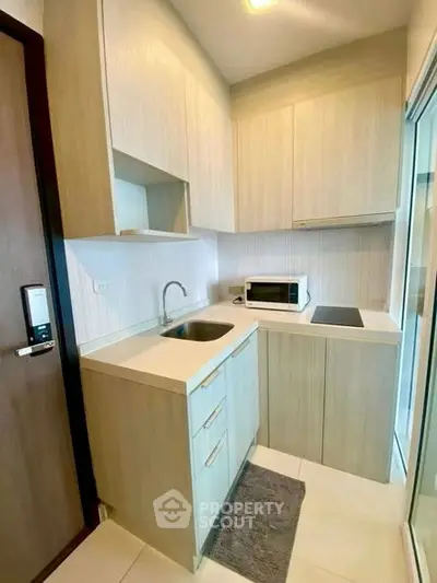 Modern compact kitchen with sleek cabinetry and built-in appliances