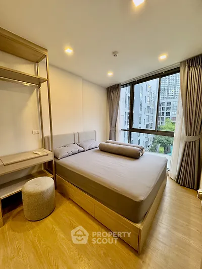Modern bedroom with large window and stylish decor in urban apartment