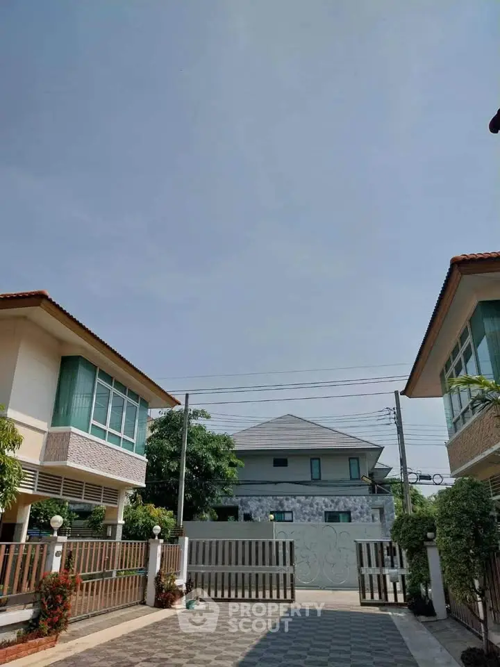 Charming suburban homes with gated entrance and clear blue sky.