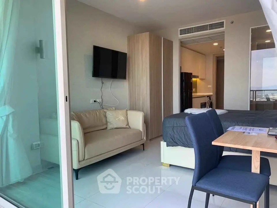 Modern studio apartment with open layout, featuring a cozy living area and compact kitchen.