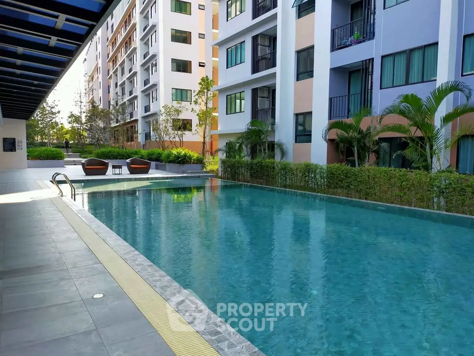 Luxurious apartment complex with a stunning outdoor pool and modern architecture.