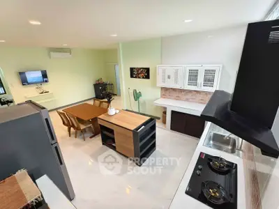 Modern open-layout kitchen and dining area with sleek appliances and stylish decor.