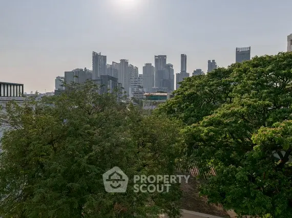 Stunning city skyline view with lush greenery in the foreground, perfect for urban living enthusiasts.