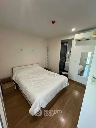 Cozy bedroom with modern decor and wooden flooring in a stylish apartment.