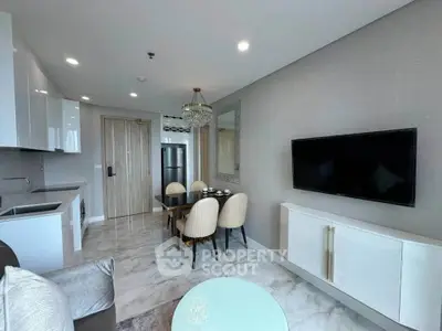 Modern living room with sleek kitchen, elegant dining area, and wall-mounted TV in a stylish apartment.