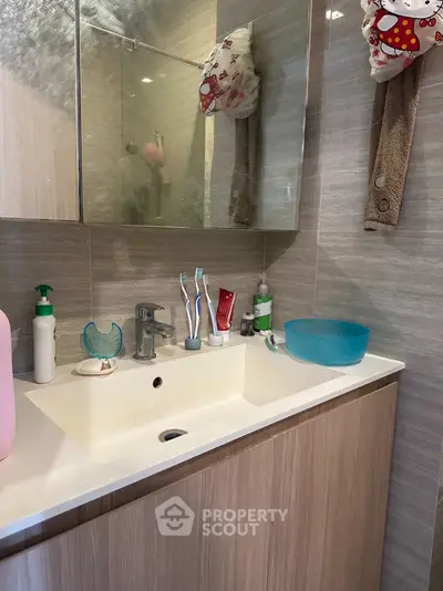 Modern bathroom with sleek sink and stylish fixtures in contemporary home.