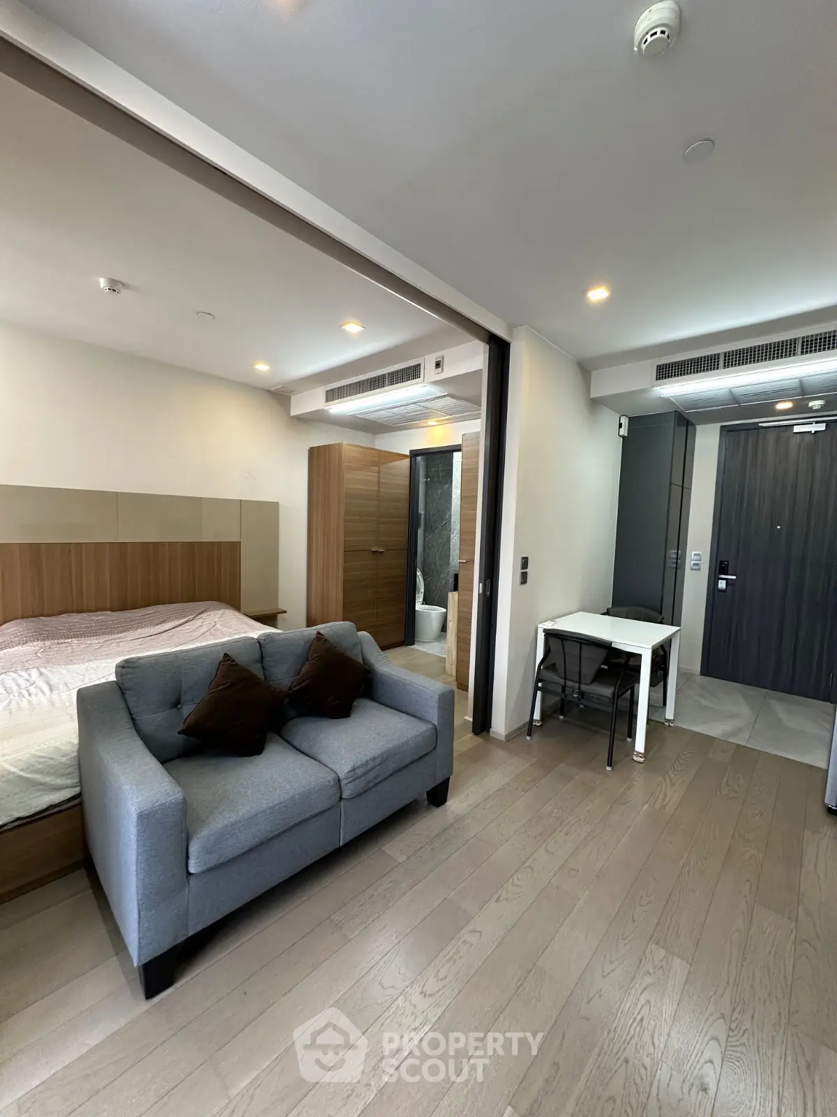 Modern studio apartment with open layout, featuring a cozy living area and stylish bedroom.