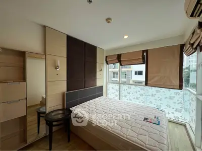 Modern bedroom with large windows and stylish decor in a high-rise apartment.