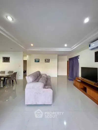 Spacious modern living room with sleek furniture and ambient lighting