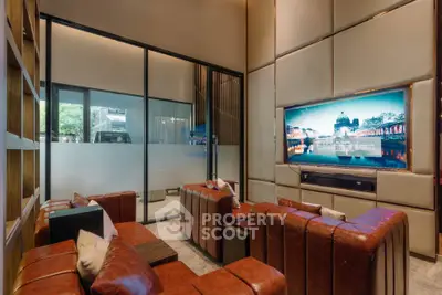 Luxurious living room with leather sofas and large TV, perfect for entertainment and relaxation.