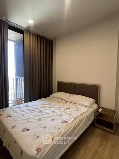 Cozy bedroom with floral bedding and balcony access in modern apartment