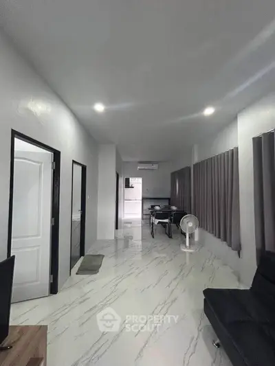Spacious modern living area with sleek marble flooring and contemporary furnishings.