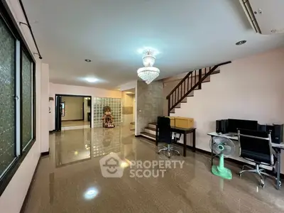 Spacious living room with elegant chandelier and modern staircase