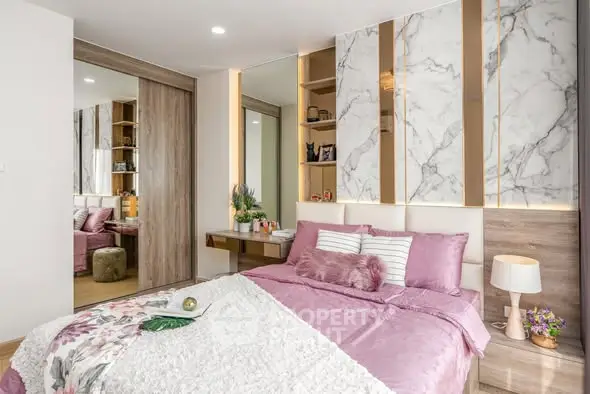 Luxurious bedroom with elegant marble accents and plush pink bedding