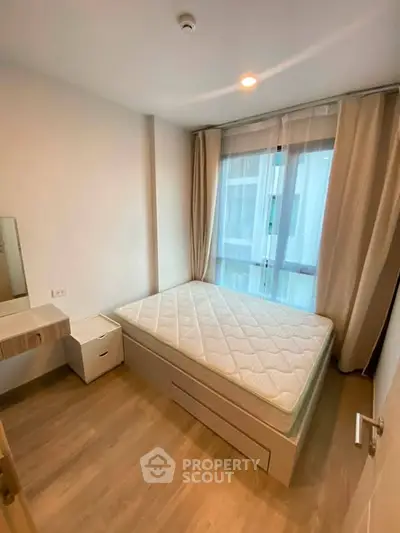Cozy bedroom with natural light and modern furnishings in a stylish apartment.